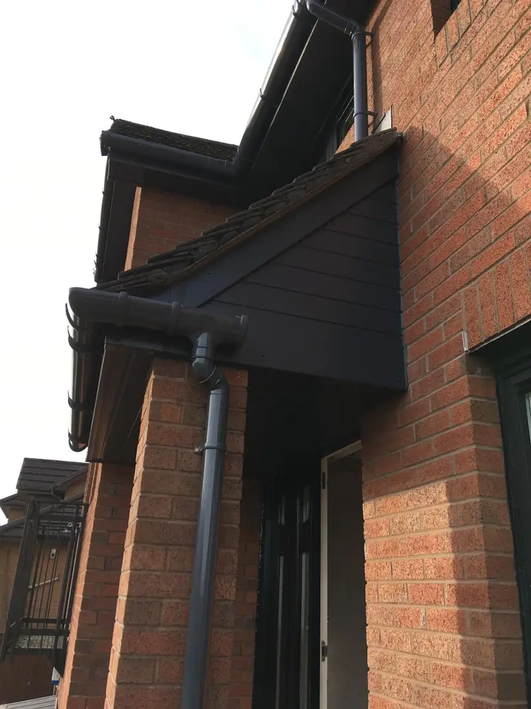 Porch gable clad in anthracite grey uPVC with matching grey Porch gable clad in anthracite grey uPVC with matching grey guttering and round downpipe