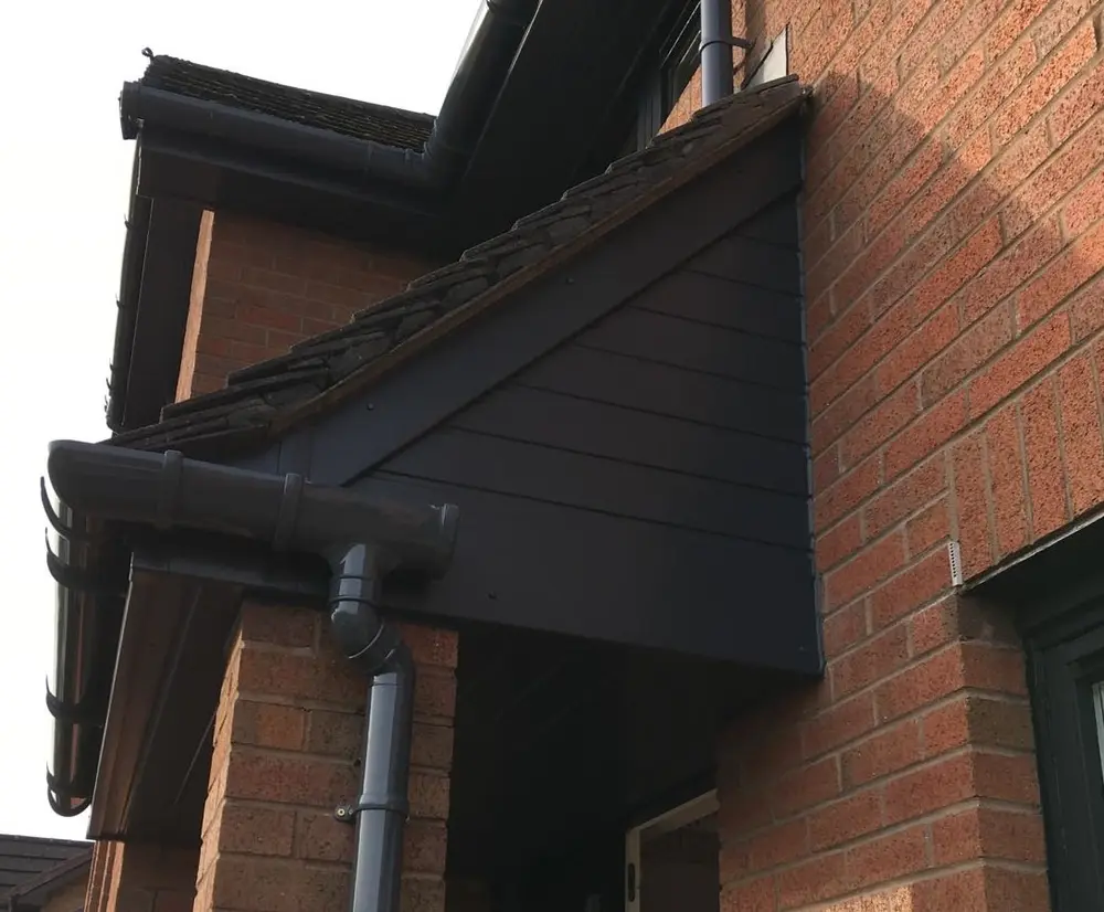 After: the same porch gable finished in anthracite grey uPVC After: the same porch gable finished in anthracite grey uPVC cladding with new grey guttering